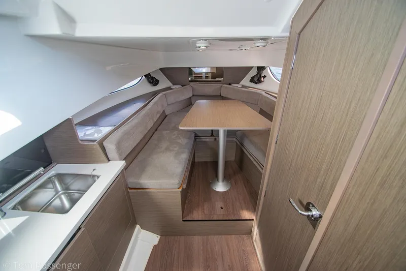 Slide: The Image of 2022 Beneteau Flyer 9 interior with dining area, wooden finishes, and compact kitchen. - 15