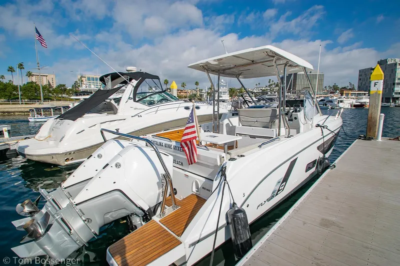 Slide: The Image of 2022 Beneteau Flyer 9 docked at marina, featuring sleek design and American flag. - 2