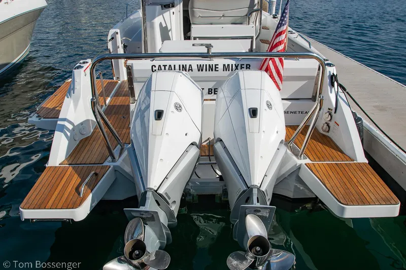 Slide: The Image of 2022 Beneteau Flyer 9 boat with twin engines, docked, featuring wooden deck and American flag. - 29