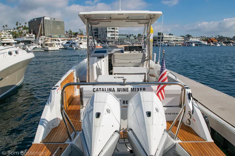 Slide: The Image of 2022 Beneteau Flyer 9 boat docked, featuring dual engines and American flag, in a marina. - 5