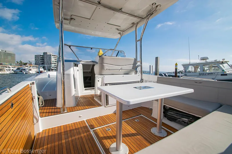 Slide: The Image of 2022 Beneteau Flyer 9 boat deck with seating and table, docked at marina. - 6