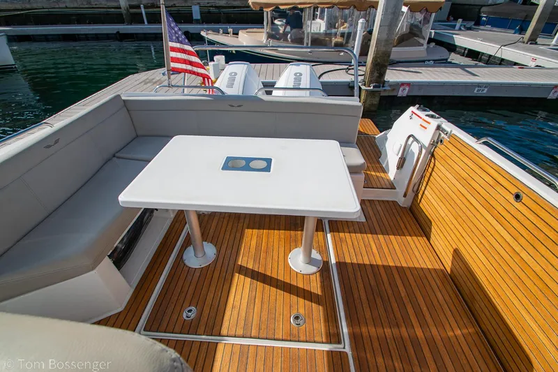 Slide: The Image of 2022 Beneteau Flyer 9 boat deck with seating, table, and American flag. - 7