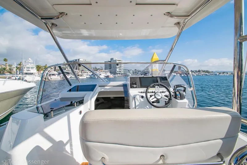 Slide: The Image of 2022 Beneteau Flyer 9 boat cockpit with steering wheel, docked in a marina. - 8