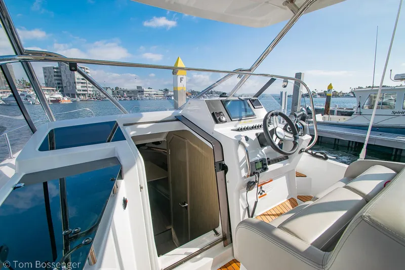 Slide: The Image of 2022 Beneteau Flyer 9 cockpit with modern controls, docked at marina. - 9