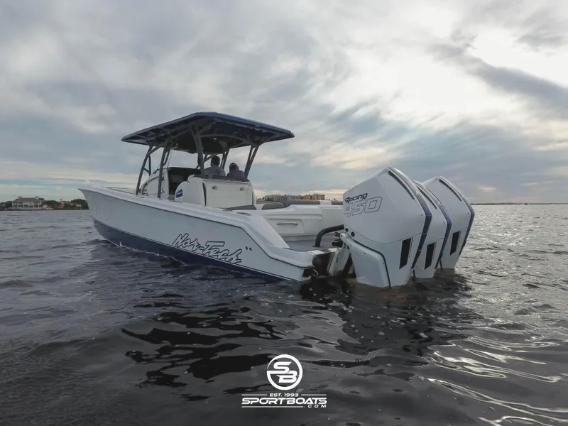 Slide: The Image of 2021 Nor-Tech 390 Sport boat on water with triple outboard engines. - 28