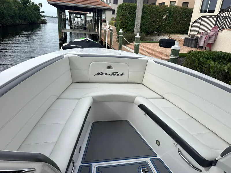 Slide: The Image of 2021 Nor-Tech 390 Sport boat with white seating and waterfront view. - 31