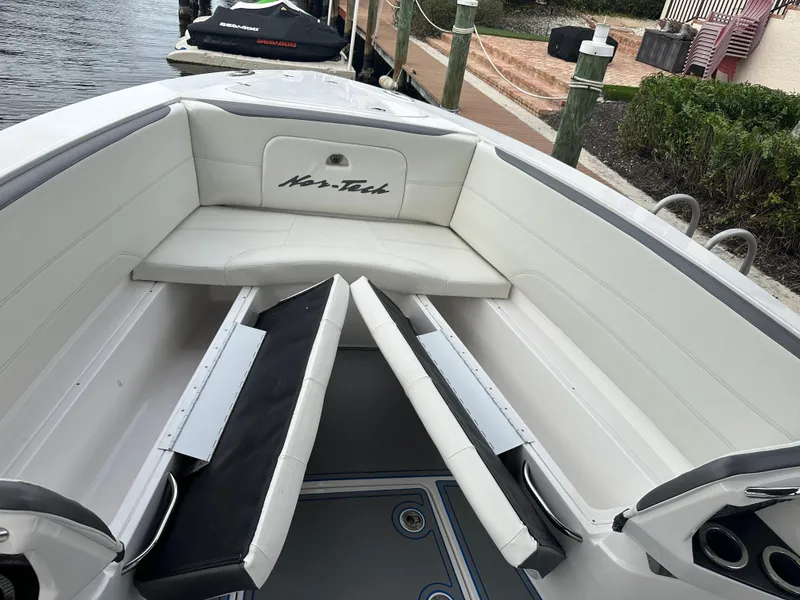 Slide: The Image of 2021 Nor-Tech 390 Sport boat interior with white seating and storage compartments. - 38