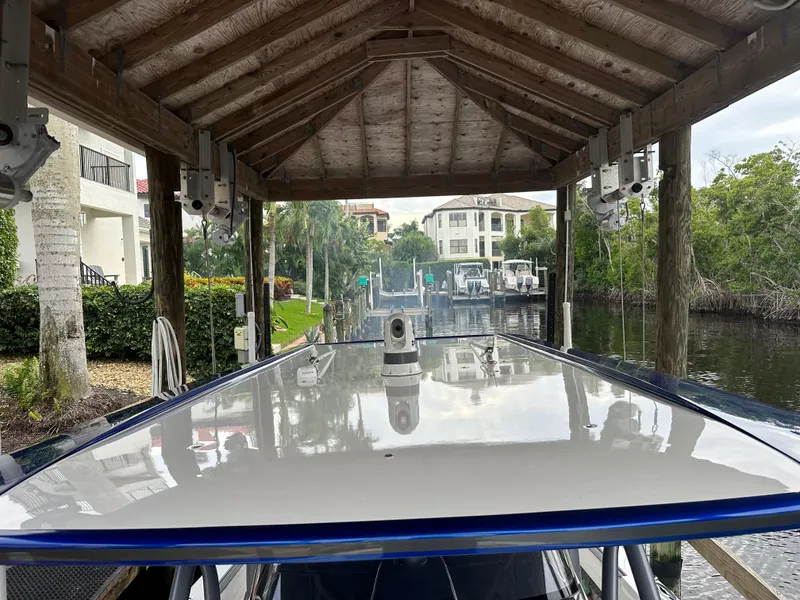 Slide: The Image of 2021 Nor-Tech 390 Sport boat docked under a wooden canopy. - 44