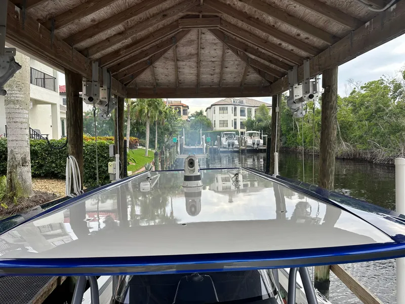 Slide: The Image of 2021 Nor-Tech 390 Sport boat docked under a wooden canopy. - 43