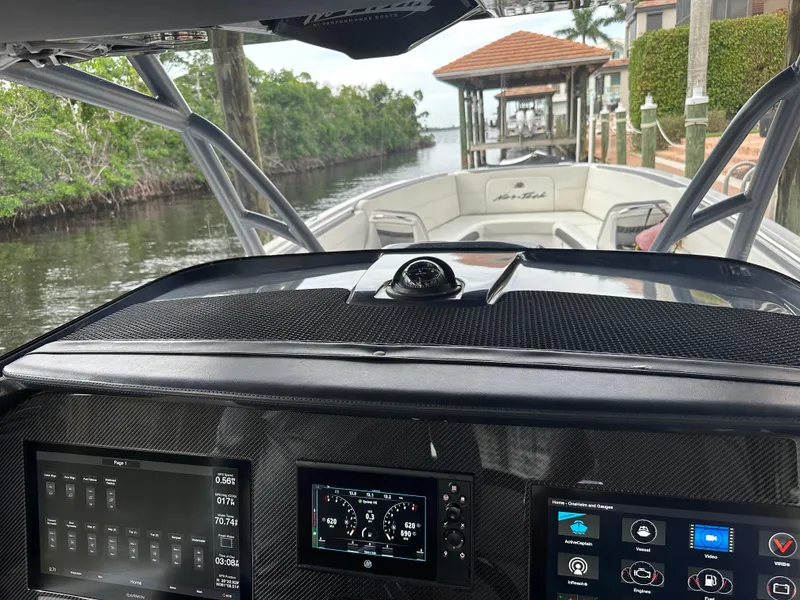 Slide: The Image of Cockpit view of 2021 Nor-Tech 390 Sport boat with advanced navigation systems. - 49
