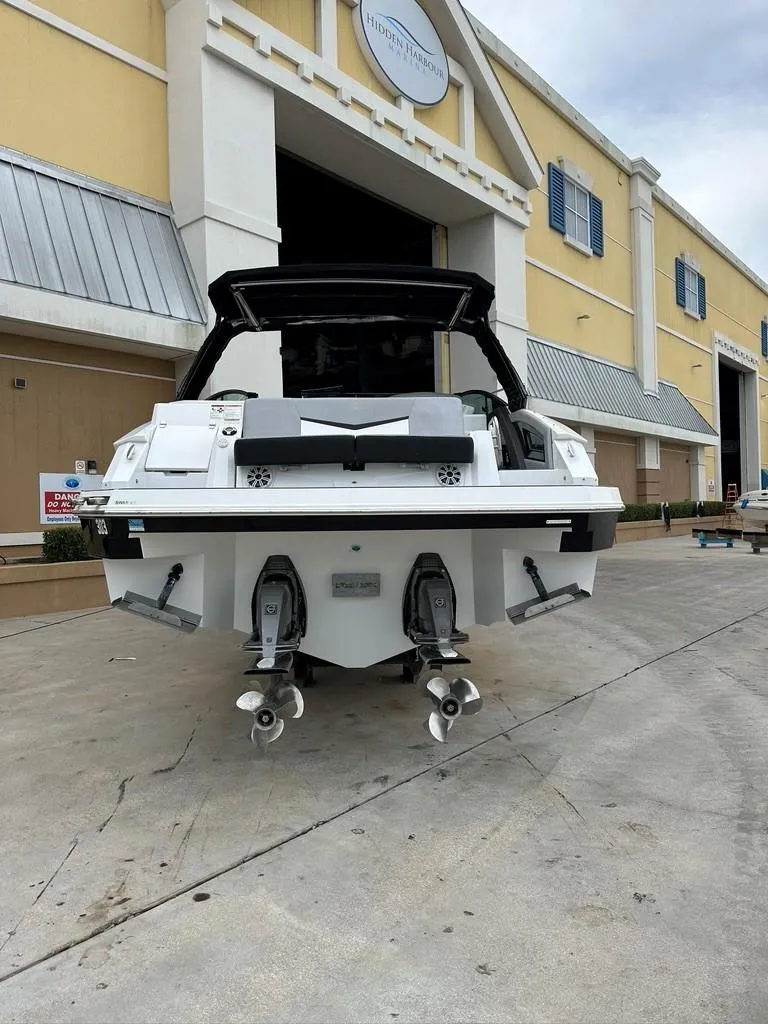 Slide: The Image of 2015 Cruisers Sport Series 328 boat docked outside a yellow building. - 1