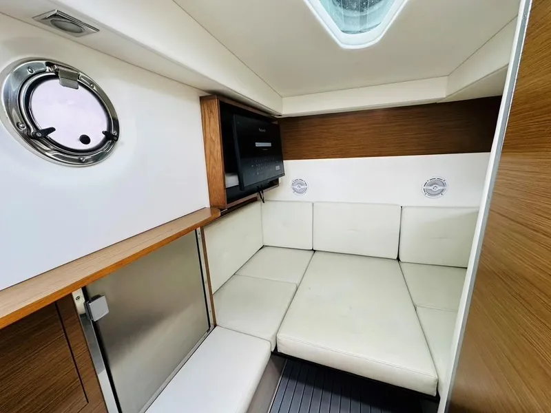 Slide: The Image of 2015 Cruisers Sport Series 328 cabin interior with white seating and wood accents. - 11