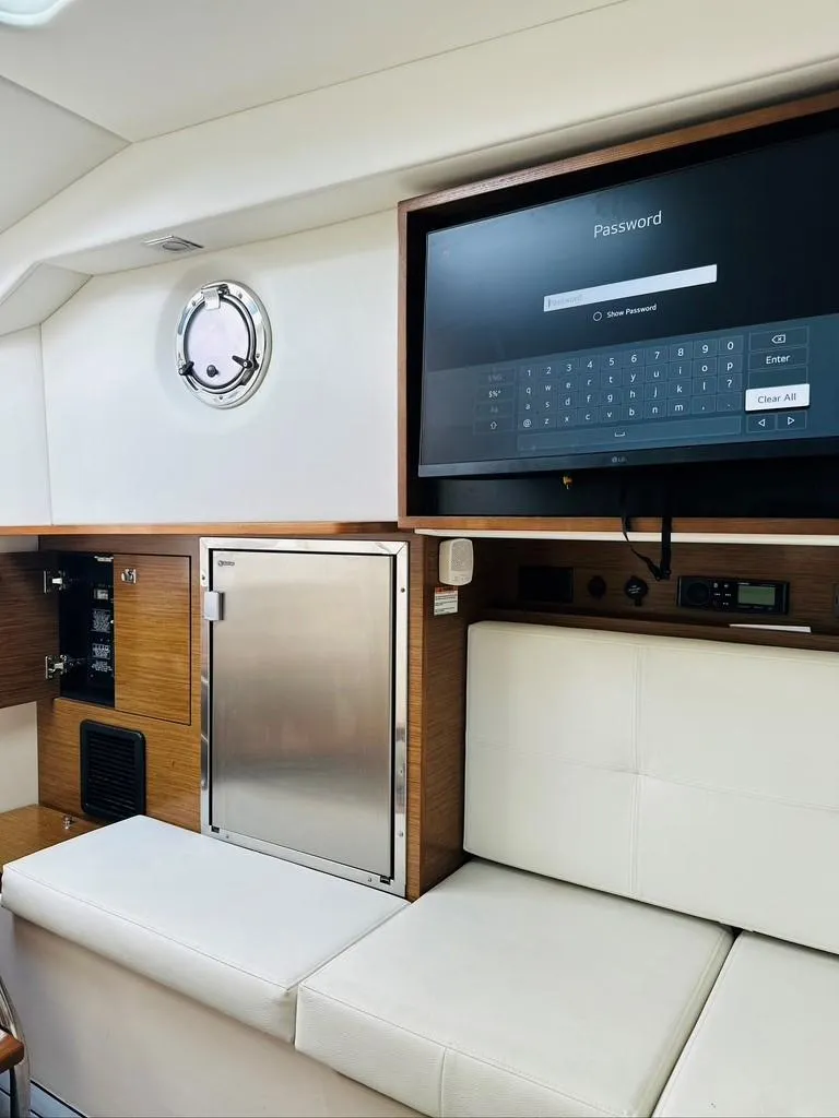 Slide: The Image of 2015 Cruisers Sport Series 328 interior with seating, storage, and mounted TV. - 12