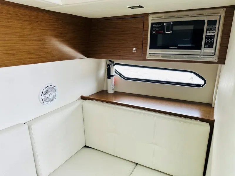 Slide: The Image of 2015 Cruisers Sport Series 328 interior with microwave, seating, and window. - 13
