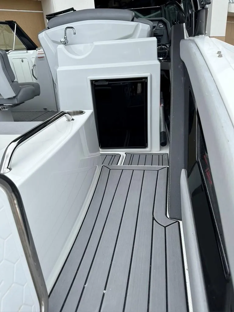 Slide: The Image of 2015 Cruisers Sport Series 328 boat interior with open cabin door and seating area. - 3