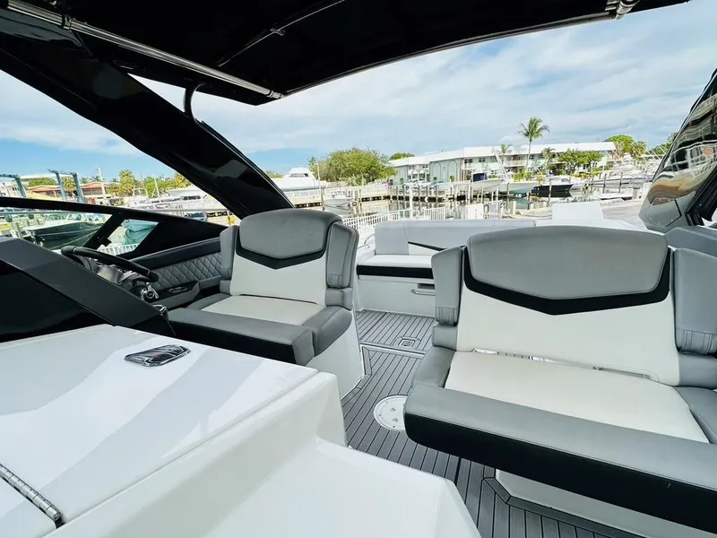 Slide: The Image of 2015 Cruisers Sport Series 328 boat interior with modern seating and marina view. - 6