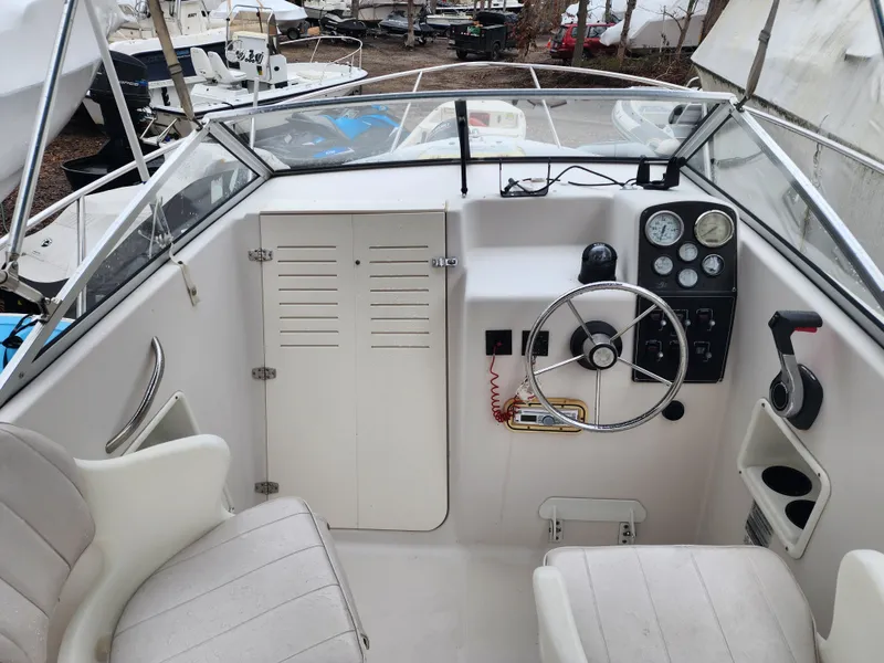 Slide: The Image of 1997 Pro-Line 201 Walkaround boat cockpit with steering wheel and gauges. - 14