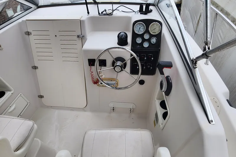 Slide: The Image of 1997 Pro-Line 201 Walkaround boat cockpit with steering wheel and instrument panel. - 16