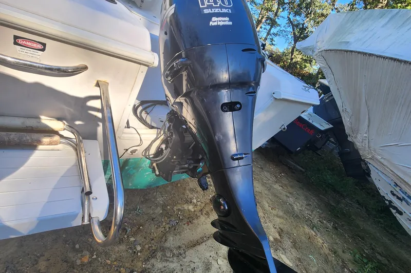 Slide: The Image of 1997 Pro-Line 201 Walkaround boat with Suzuki outboard motor, parked outdoors. - 4