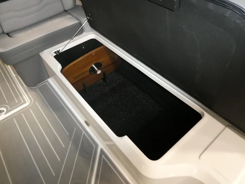 Slide: The Image of 2024 Regal LX9 boat storage compartment with cushioned seating and sleek interior design. - 31
