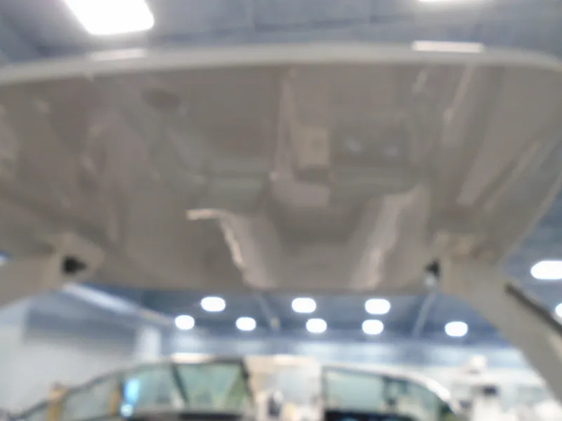 Slide: The Image of 2024 Regal LX9 boat interior with open canopy in a showroom setting. - 38