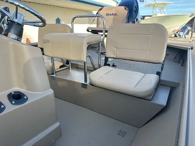 Slide: The Image of 2024 SeaArk 2072 VFX Elite CC boat interior with beige seating and steering console. - 4