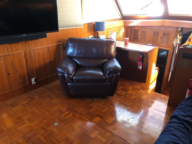 Slide: The Image of Interior of 1985 CHB Motor Yacht with leather chair and wooden flooring. - 14