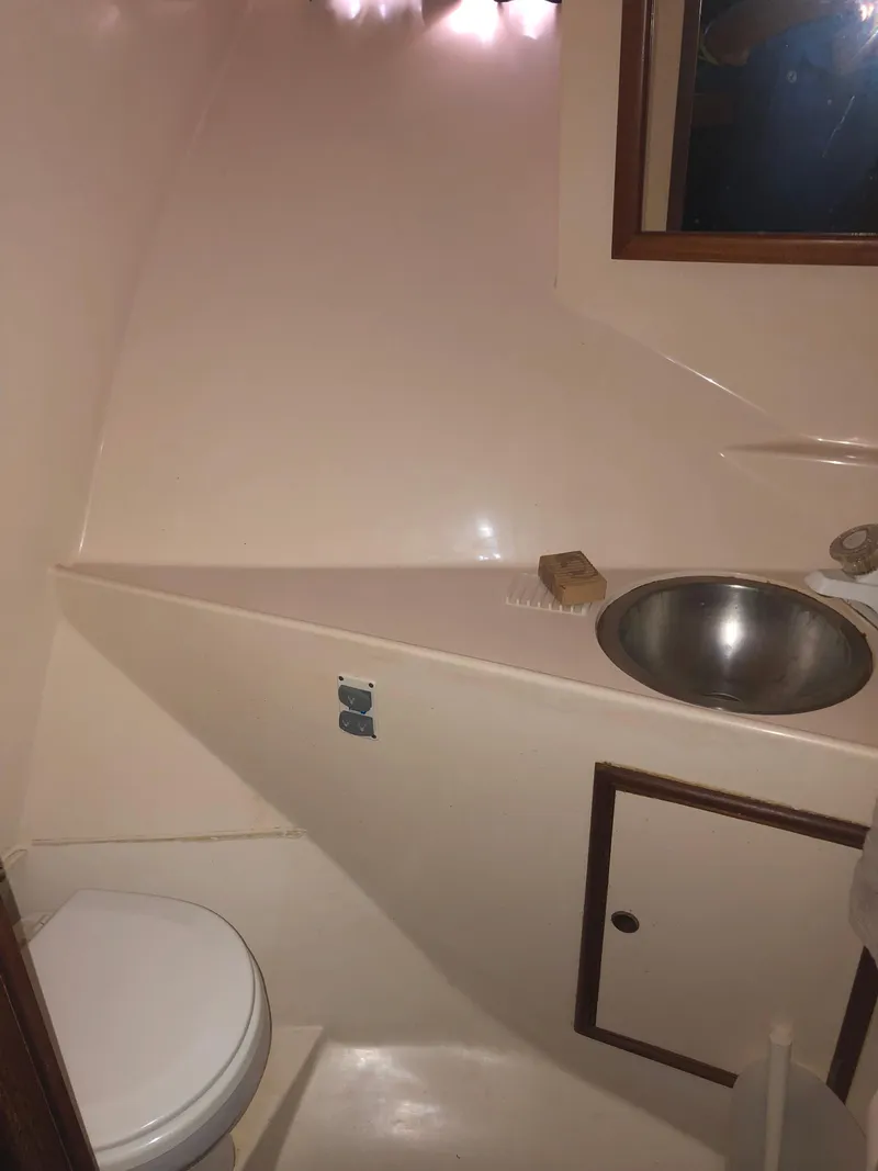 Slide: The Image of 1985 CHB Motor Yacht bathroom with toilet, sink, and storage cabinet. - 18