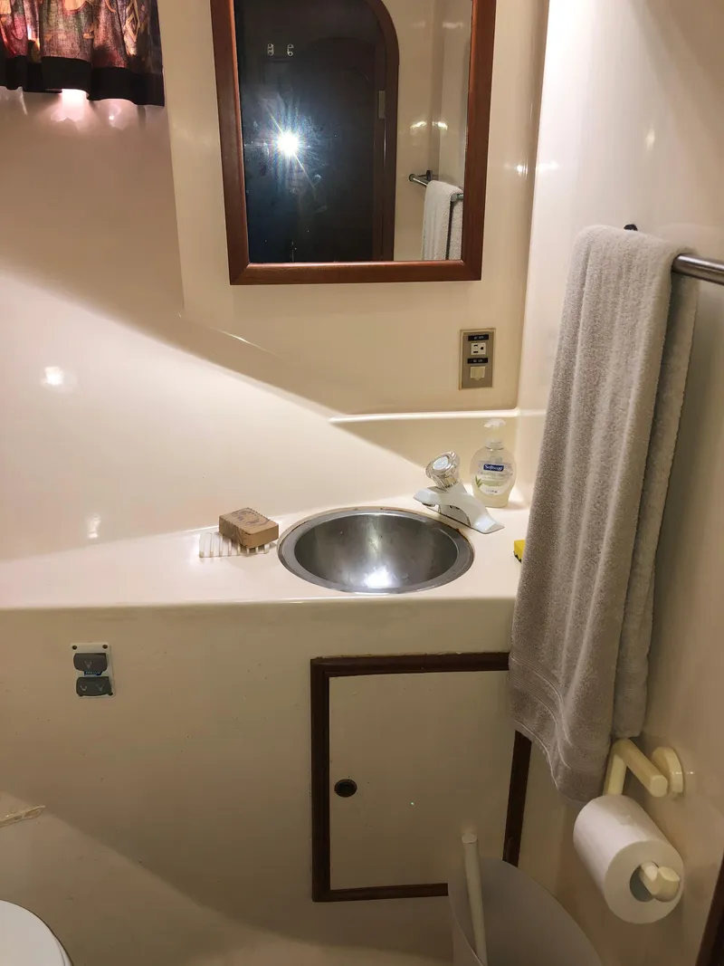 Slide: The Image of 1985 CHB Motor Yacht bathroom with sink, mirror, towel, and toiletries. - 19