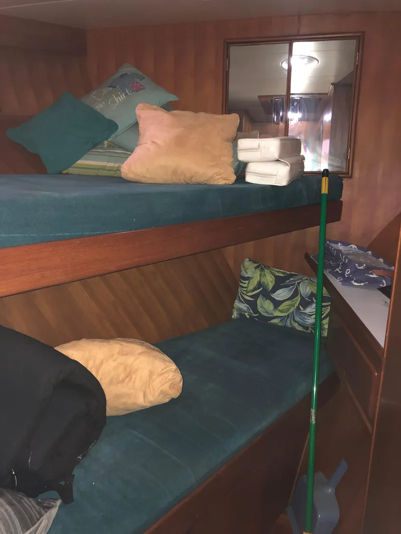 Slide: The Image of Bunk beds in the cabin of a 1985 CHB Motor Yacht with pillows and cleaning supplies. - 20