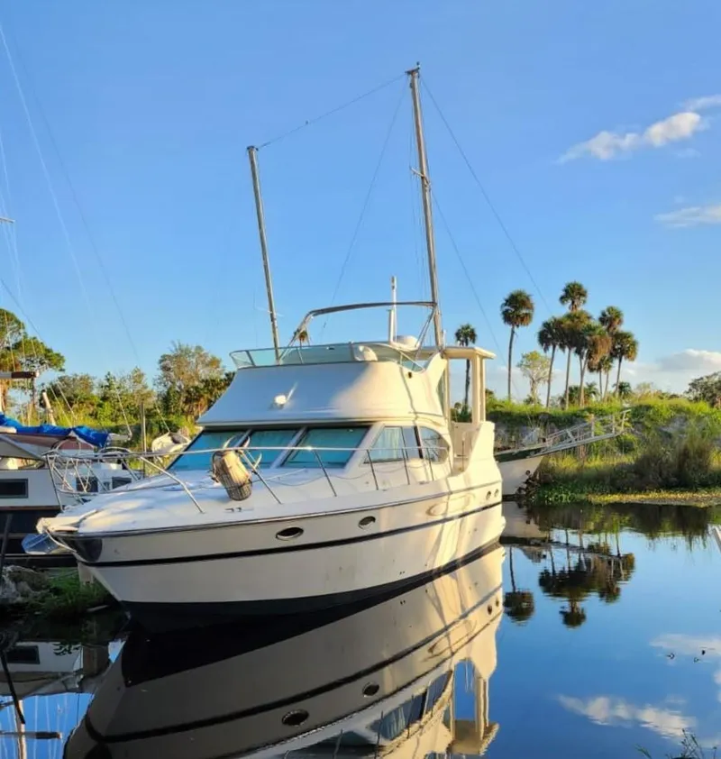 Slide: The Image of 2000 Maxum 4100 SCA yacht docked on calm water with clear blue sky. - 37