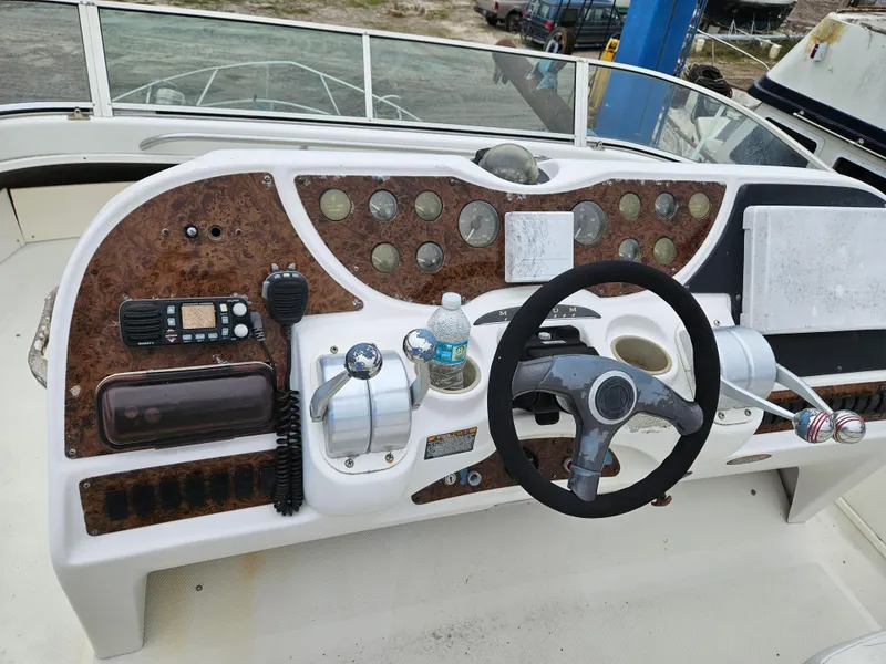 Slide: The Image of Control panel of a 2000 Maxum 4100 SCA yacht with steering wheel and navigation instruments. - 38