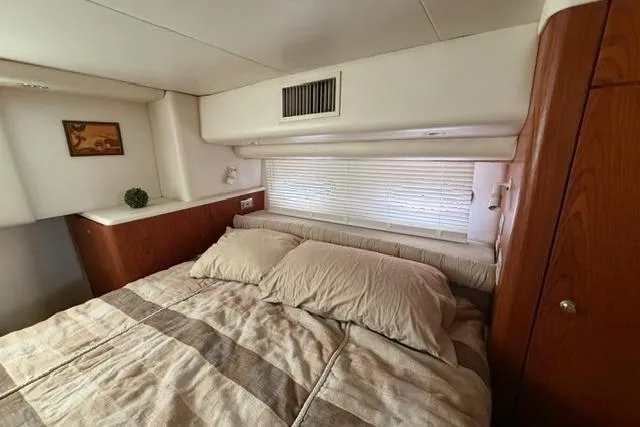 Slide: The Image of Cozy bedroom in 2000 Maxum 4100 SCA yacht with wood accents and soft bedding. - 73