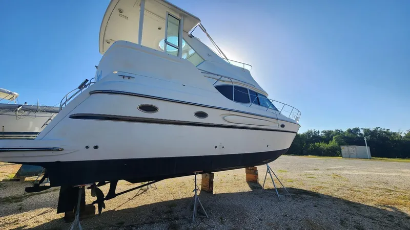 Slide: The Image of 2000 Maxum 4100 SCA yacht on dry dock under clear blue sky. - 8
