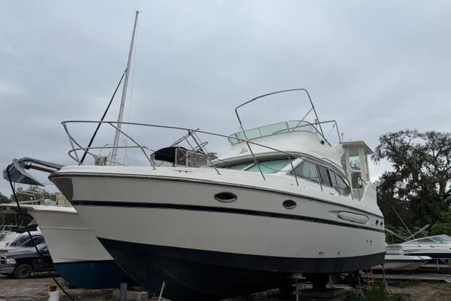 Slide: The Image of 2000 Maxum 4100 SCA yacht on land, white hull, overcast sky. - 88