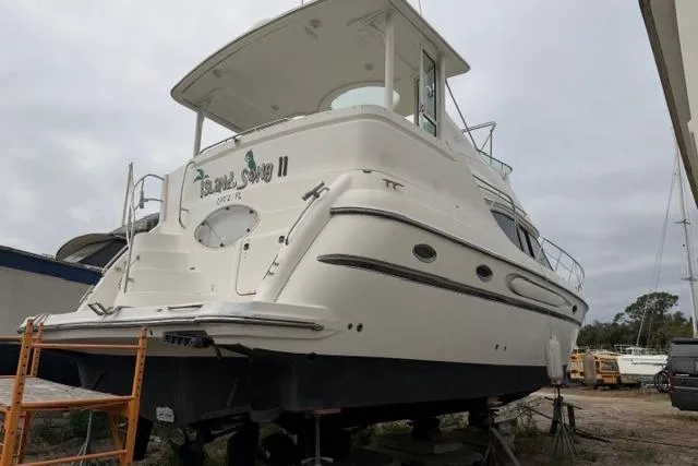 Slide: The Image of 2000 Maxum 4100 SCA yacht on dry dock, rear view, overcast sky. - 96
