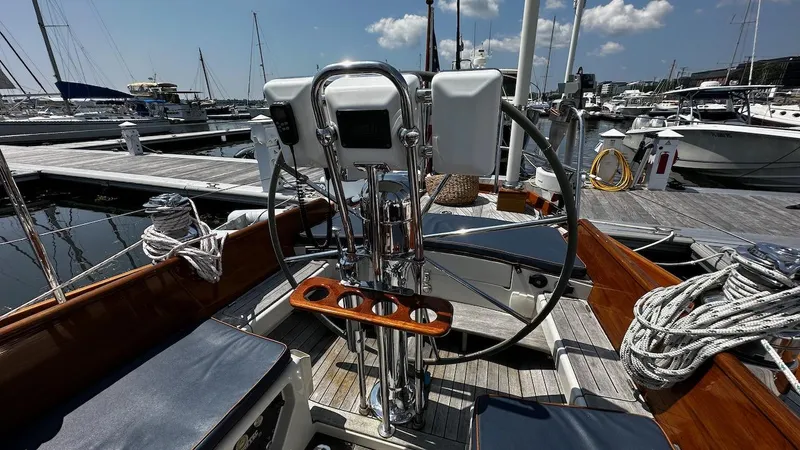 Slide: The Image of Cockpit of 2004 Lyman-Morse Sparkman & Stephens Sloop at marina, featuring steering wheel and navigation instruments. - 16