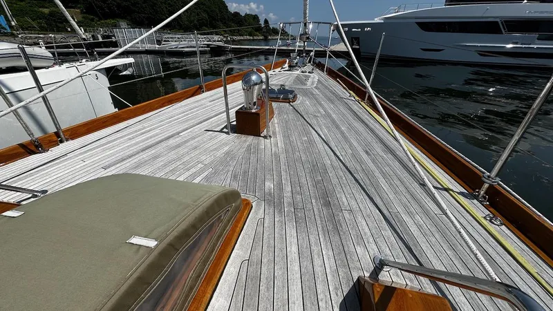 Slide: The Image of Deck of 2004 Lyman-Morse Sparkman & Stephens Sloop at marina, showcasing wooden finish and sleek design. - 30