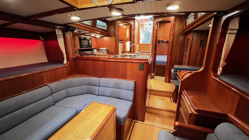 Slide: The Image of Interior of 2004 Lyman-Morse Sparkman & Stephens Sloop with wood finish and blue seating. - 49
