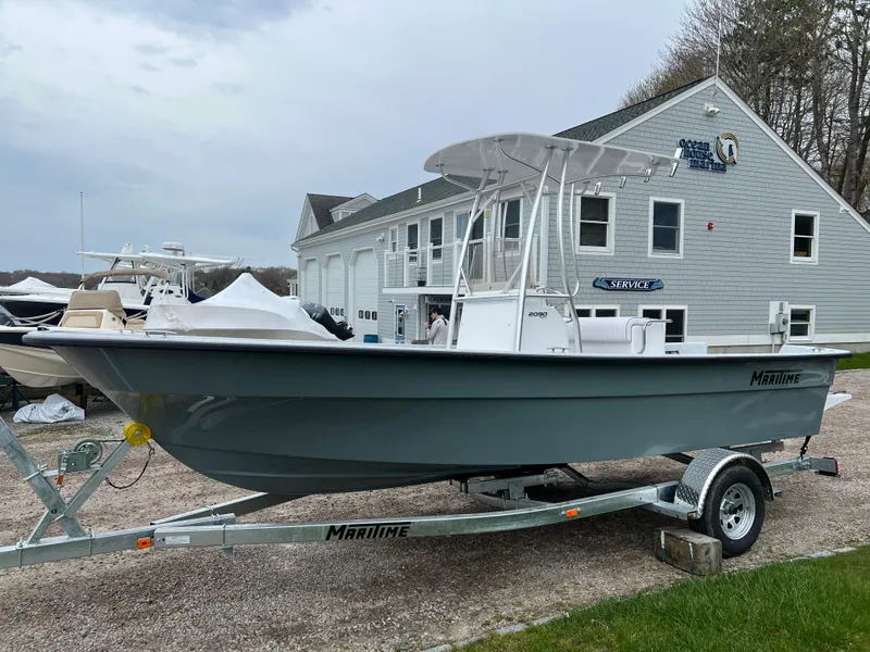 Slide: The Image of 2024 Maritime 2090 Skiff boat on trailer outside a marine service building. - 12