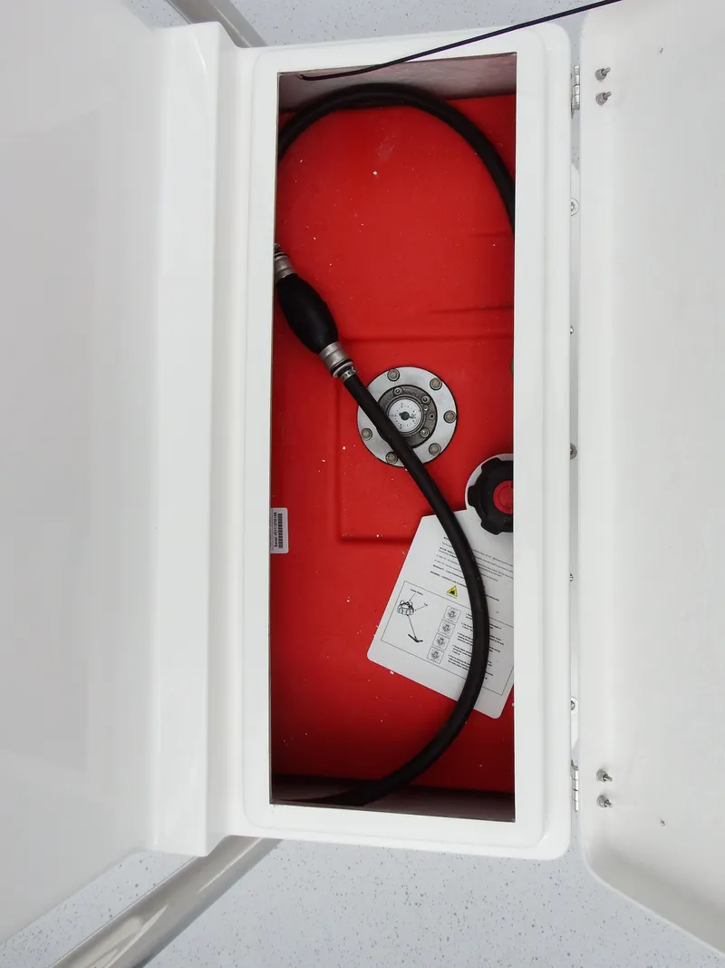 Slide: The Image of 2024 Maritime 2090 Skiff fuel tank compartment with hose and manual. - 27