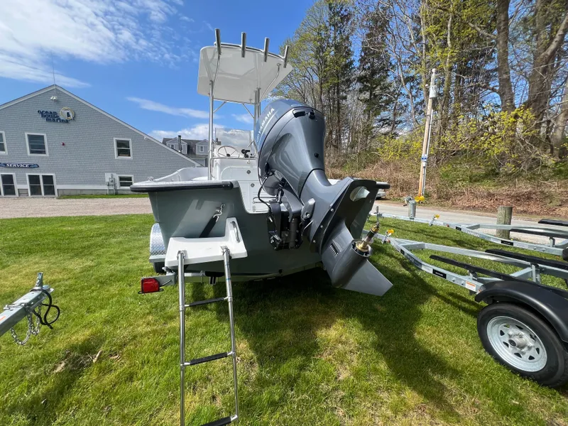 Slide: The Image of 2024 Maritime 2090 Skiff boat with outboard motor and trailer on grassy area. - 6