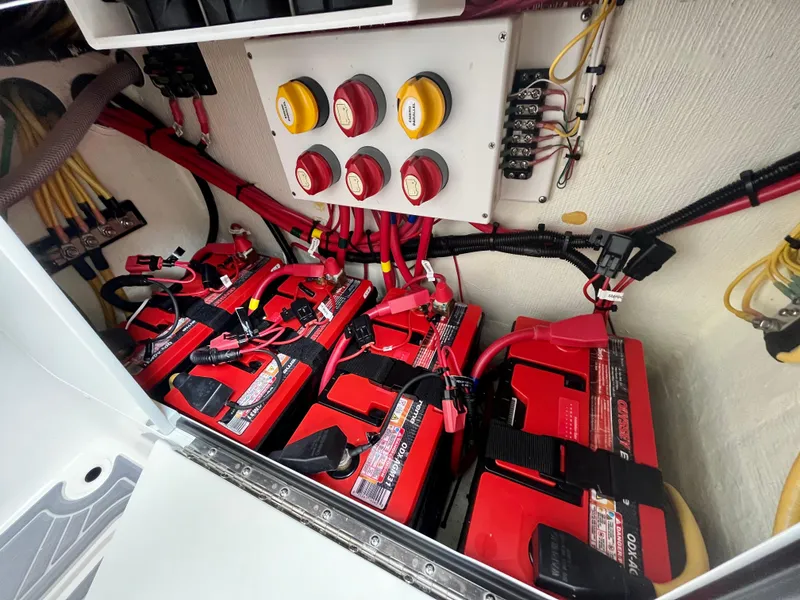 Slide: The Image of Battery compartment of 2023 Invincible 36' Open Fisherman boat with red batteries and control panel. - 17