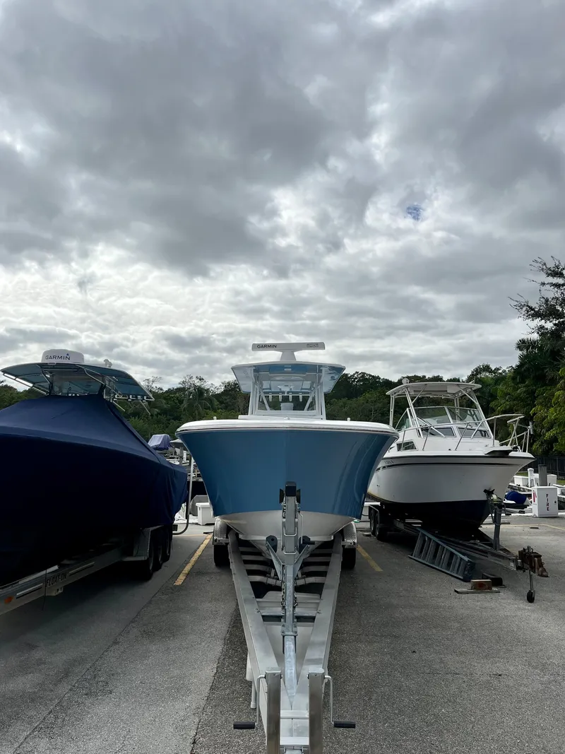 Slide: The Image of 2023 Invincible 36' Open Fisherman boat on trailer in marina. - 36