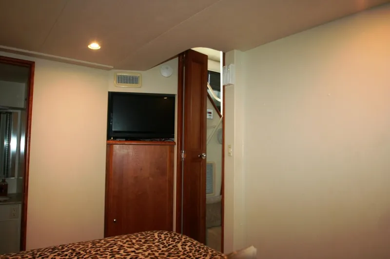 Slide: The Image of Interior cabin of 2000 Silverton 392 Motor Yacht with TV and wooden cabinetry. - 15