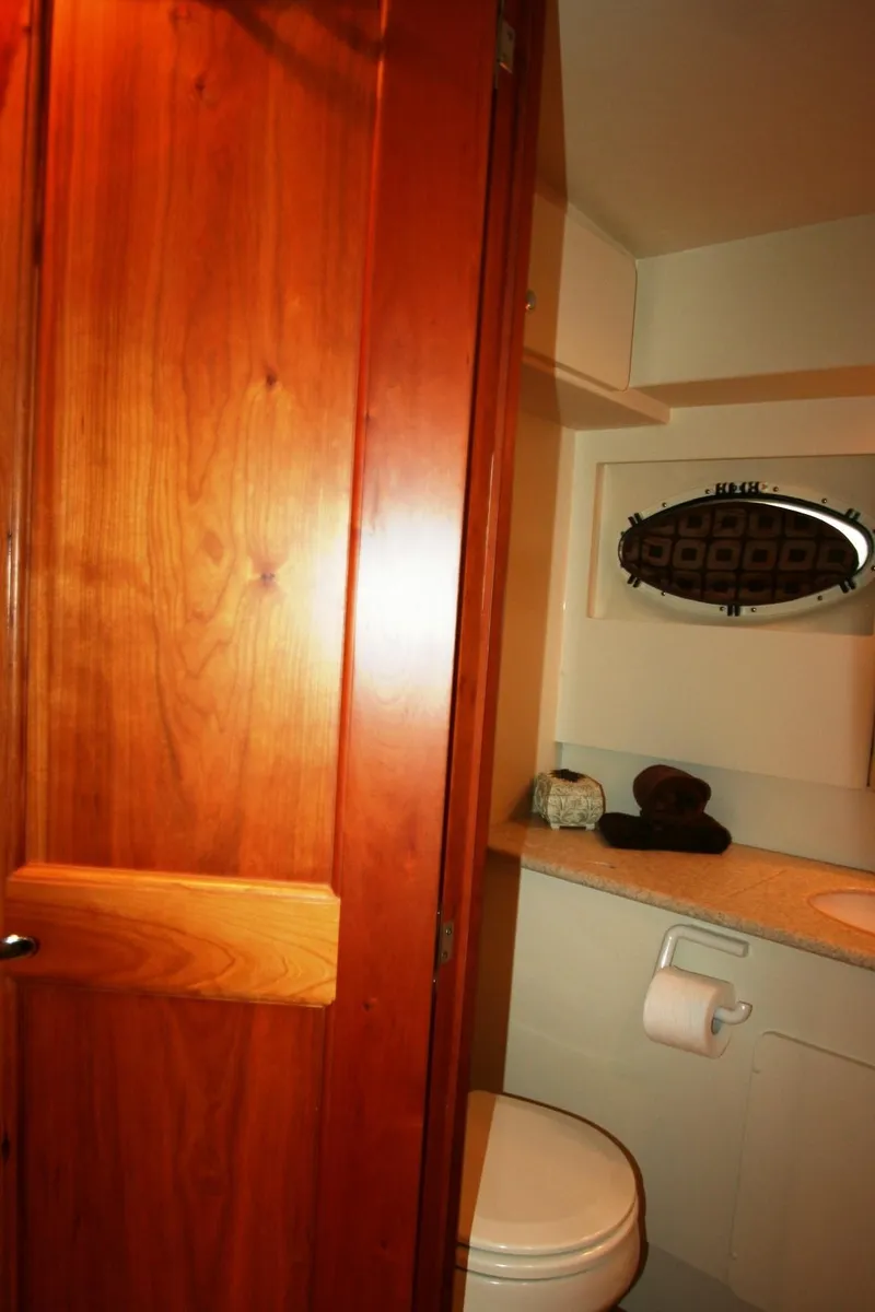 Slide: The Image of 2000 Silverton 392 Motor Yacht bathroom with wooden door and compact amenities. - 18