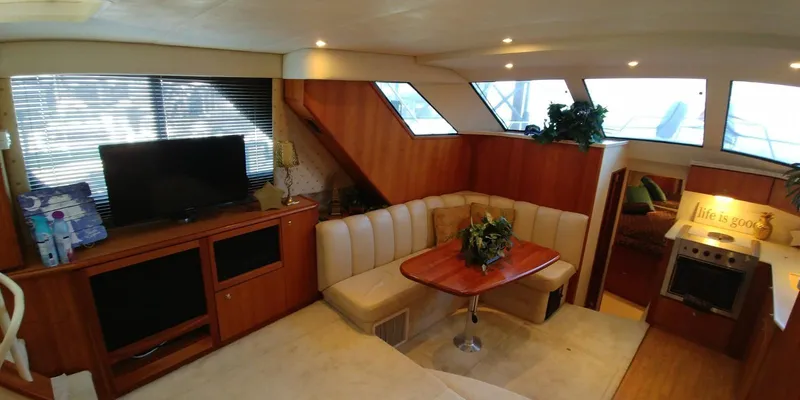 Slide: The Image of Interior of 2000 Silverton 392 Motor Yacht with cozy seating, TV, and kitchen area. - 3