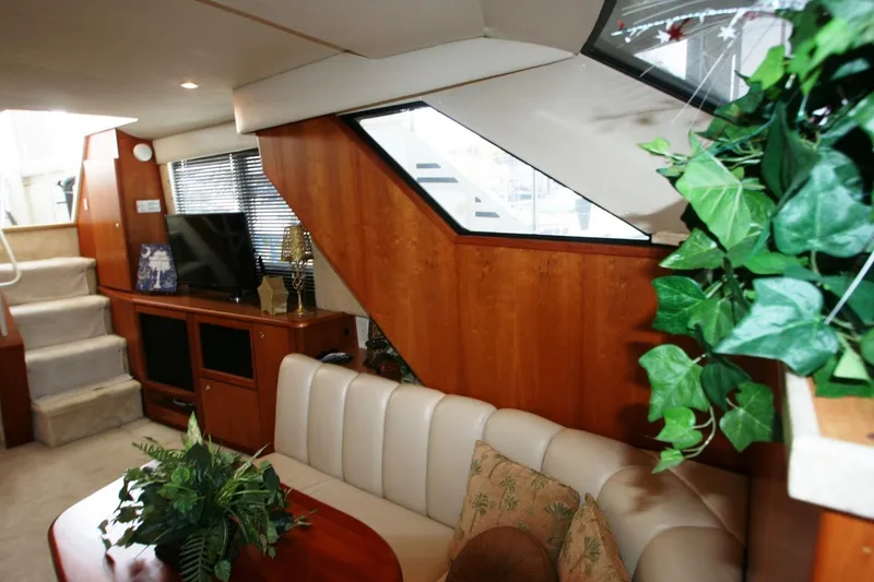 Slide: The Image of Interior of 2000 Silverton 392 Motor Yacht with beige seating, wooden cabinetry, and green plants. - 37
