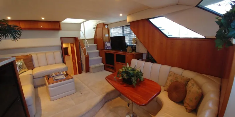 Slide: The Image of Interior of 2000 Silverton 392 Motor Yacht with plush seating and wooden accents. - 4