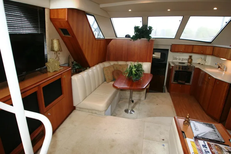 Slide: The Image of 2000 Silverton 392 Motor Yacht interior with cozy seating, dining table, and modern amenities. - 41